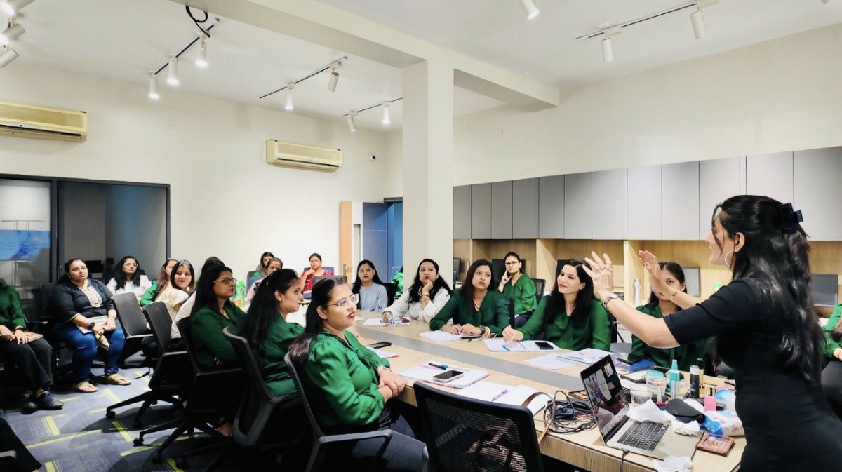 Prerna Maheshwari mid-gesture while training a corporate team in a modern office